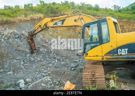 Bulldozer equip with drill, breaking down a hill landscape for homes and buildings. Stock Photo