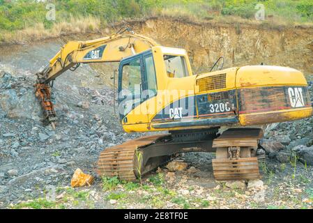 Bulldozer equip with drill, breaking down a hill landscape for homes and buildings. Stock Photo