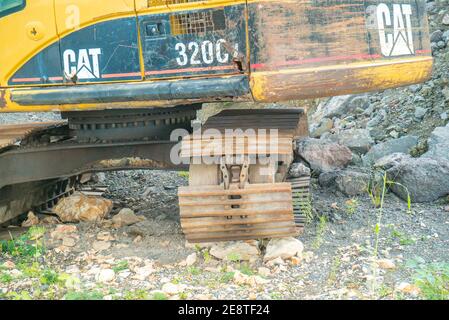 Bulldozer equip with drill, breaking down a hill landscape for homes and buildings. Stock Photo