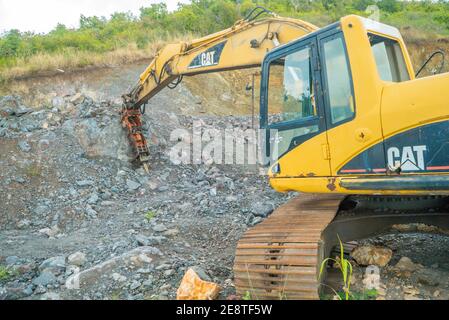 Bulldozer equip with drill, breaking down a hill landscape for homes and buildings. Stock Photo