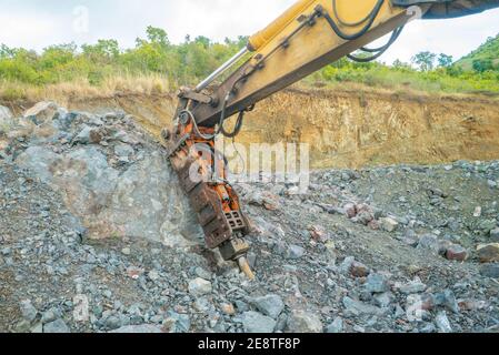 Bulldozer equip with drill, breaking down a hill landscape for homes and buildings. Stock Photo