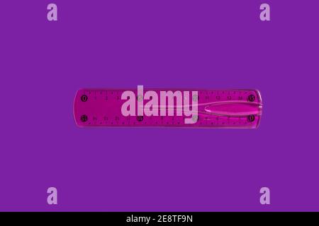 pink ruler on a purple background Stock Photo