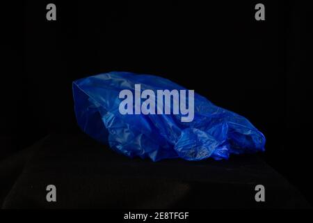 discarded and new blue virus inspection  plastic glove isolated on a black background Stock Photo