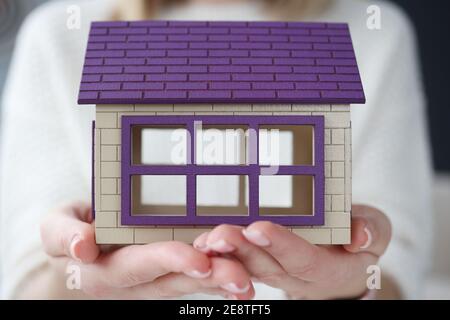 Woman holding toy wooden house in her hands Stock Photo