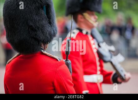 British ceremonial guardsmen with red tunics and bearskin hats parading during the annual Trooping of the Colour ceremony for the Queen's birthday. Stock Photo