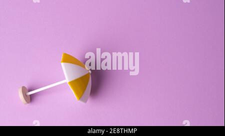 multicolored beach umbrella on pink background Stock Photo