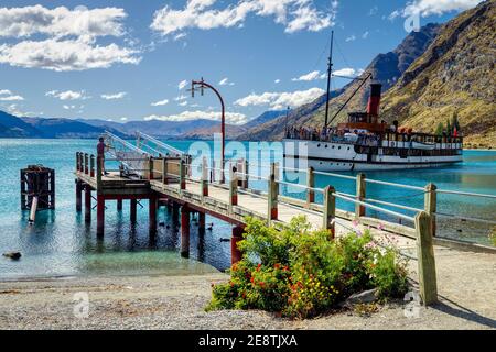 The 1912 TSS Earnslaw, an Edwardian twin screw steamer, arrives at Beach Bay on Lake Wakatipu to dock at Walter Peak High Country Farm, New Zealand. Stock Photo