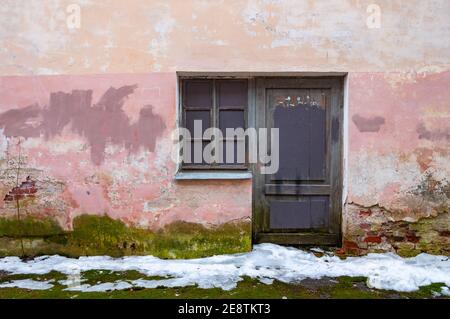 The brick wall of an old building with ruined plaster. Stock Photo