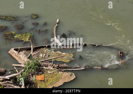 Boat wreck in the Tiber river in Italy, sunken and partially covered with water Stock Photo
