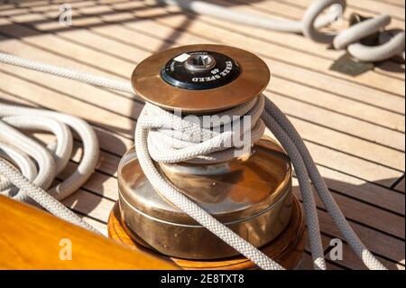 Sheet winch on a  wooden old yacht deck. Close up Stock Photo