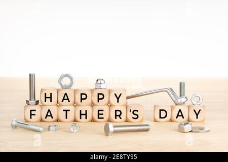 Happy fathers day concept. Wooden blocks with text on table with wrench, nuts and screws. Copy space. White background Stock Photo