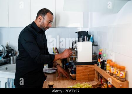 Handsome man making coffee at home Stock Photo