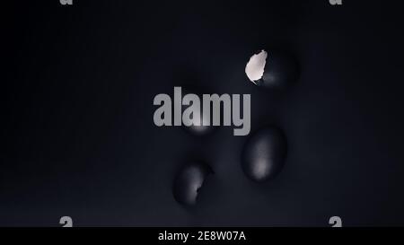 Some black painted Easter eggs on black background, flat lay with copy space Stock Photo