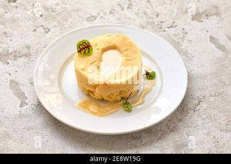 portion of pureed potatoes with melted butter on white plate Stock Photo