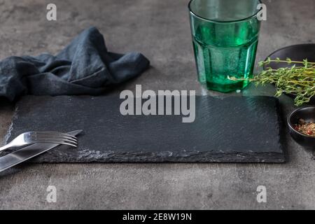 empty black stone plate on black restaurant table Stock Photo