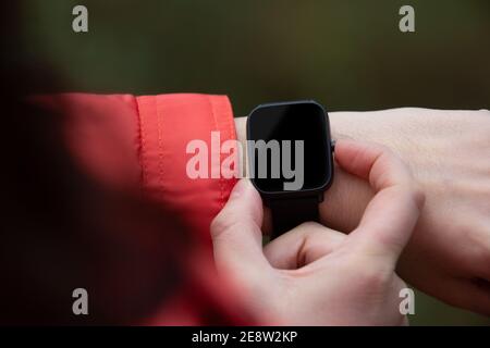 Close-up view of a woman using her smart watch in nature Stock Photo