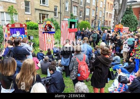 People watch a Punch and Judy show at the Covent Garden May Fayre and Puppet Festival, London, UK Stock Photo
