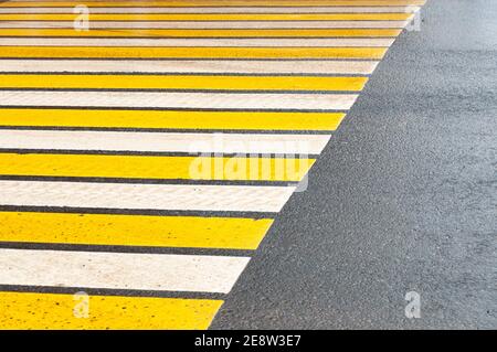 Crosswalk on the street for safety, white and yellow stripes Stock Photo