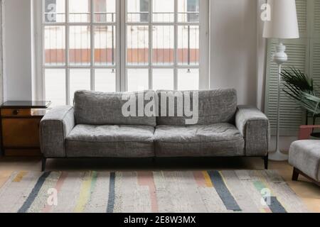 Comfortable grey couch standing in modern empty living room Stock Photo