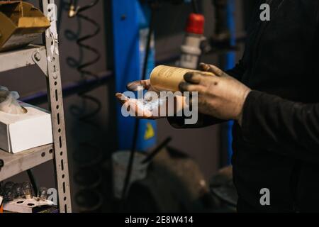 Mechanic washing his hands with talcum powder. Mechanics and cleaning concept. Stock Photo