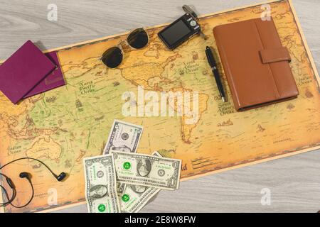 top view of travel concept with passports, travel photo camera, sunglasses, diary and pen to take notes, headphones for listening to music and money b Stock Photo