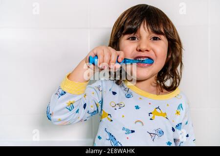cheerful child brushing his teeth in his pajamas before bedtime Stock Photo