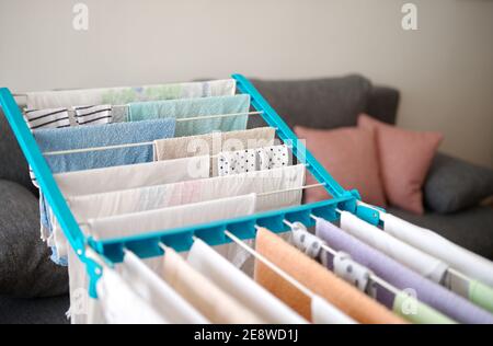 Drying laundry on drying rack in a small living room Stock Photo