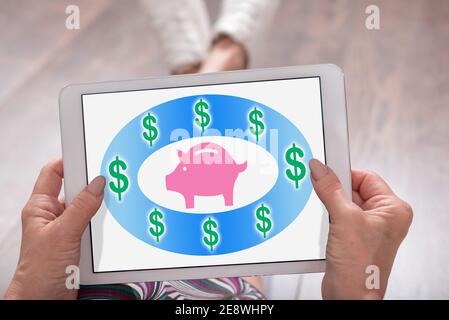 Saving money concept shown on a tablet held by a woman Stock Photo