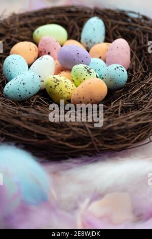 Colorful pastel colored easter eggs in bird's nest top view with bright feasthers top view, April, Easter Holliday, Religion and spring concept Stock Photo