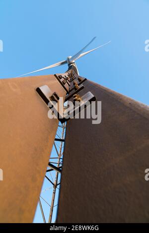 Old rusty wind turbine against a blue sky background Stock Photo - Alamy