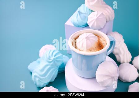 Espresso cup with foam. Meringues of different colors on a blue background and Coffee. Meringue. A creative shot of protein and sugar cookies. High quality photo. Copy space Stock Photo