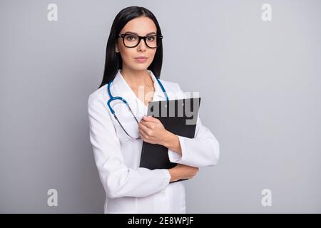 Photo of confident serious lady doctor wear white coat eyeglasses hugging embracing clipboard isolated grey color background Stock Photo