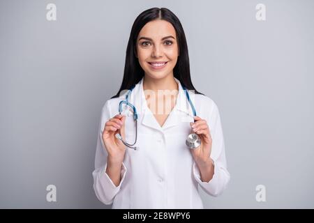Photo of cheerful doctor girl hold equipment toothy smile wear stethoscope white uniform isolated grey color background Stock Photo