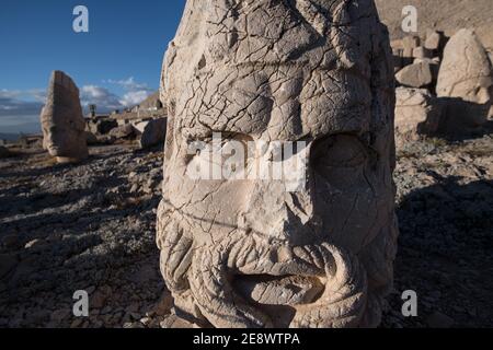 A close-up of an ancient stone head at Mount Nemrut, Turkey, revealing the weathered details and enigmatic expression carved by skilled artisans. Stock Photo