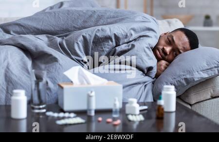 Sick Black Guy Having Chills Lying On Couch At Home Stock Photo