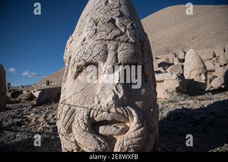 A close-up of an ancient stone head at Mount Nemrut, Turkey, revealing the weathered details and enigmatic expression carved by skilled artisans. Stock Photo