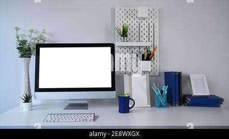 Stylish workplace with mock up computer and office supplies on white table. Stock Photo