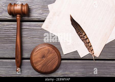 Flat lay wooden gavel and feather. Stock Photo