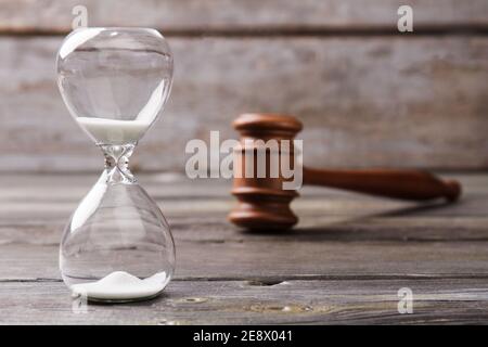 Close-up hourglass and judge gavel.