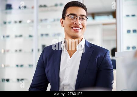 Dark-haired male wearing a new pair of trendy spectacles Stock Photo