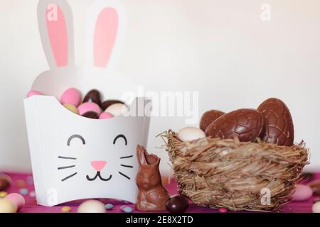 Rabbit treat box with sweet almond eggs and nest with chocolate eggs Stock Photo