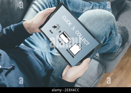 close-up of person on sofa holding tablet computer for online shopping using a click and collect service Stock Photo