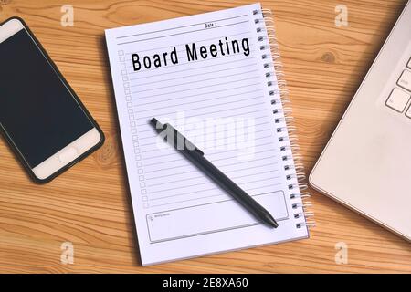 Board Meeting label on notepad with laptop and smartphone Stock Photo
