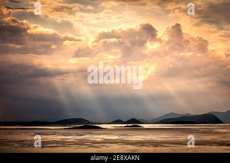 Sun rays filter through clouds over Lake Cuitzeo in Michoacan, Mexico. Stock Photo