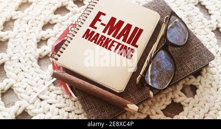 E-MAIL MARKETING words written on cover of book, eyeglasses and pen. Business concept. Stock Photo