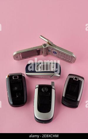 broken mobile phones, recycling technology, early 2000s on pink background and copy space,. Stock Photo