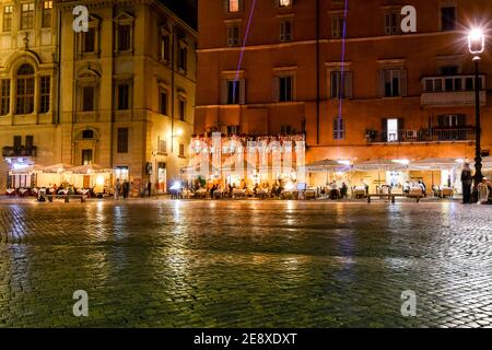 Illuminated cafes and restaurants with tourists late night at the Piazza Navona in Rome, Italy. Stock Photo