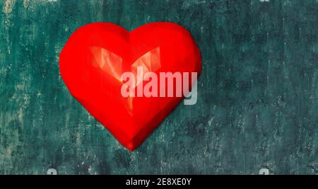 Large volumetric 3D red heart folded using the origami technique on a blue wall made of textured plaster. Greeting card for Valentine's Day, declarati Stock Photo