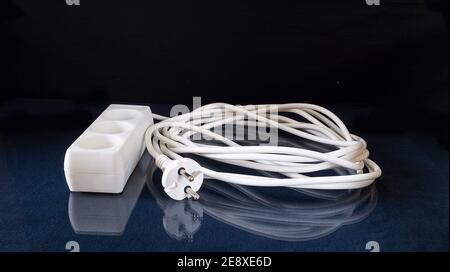 Network extension Cable rests upon glass table with reflection.Subjects on black background close-up Stock Photo