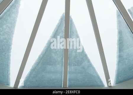 close up of snow on conservatory roof, from inside looking out, creating a petal and linear shaped pattern Stock Photo